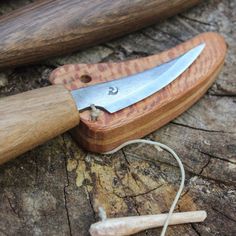 a knife is laying on top of a piece of wood