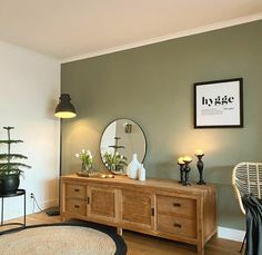 a living room with a large mirror and wooden furniture on the floor next to a plant