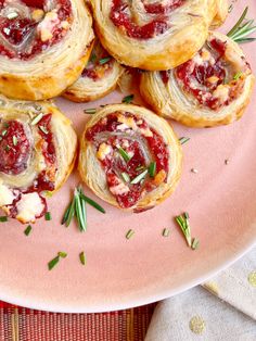 small pastries on a pink plate with rosemary sprigs and cranberry sauce