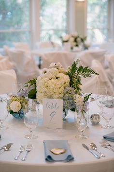 the table is set with white flowers and silverware for an elegant wedding breakfasteon