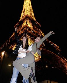 two people are posing in front of the eiffel tower