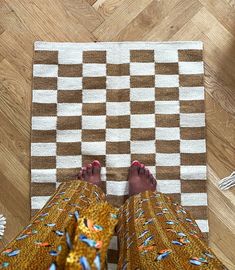 a person standing on a rug with their feet propped up against the floor and legs crossed