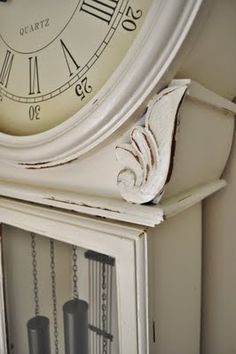 an old white clock on top of a cabinet