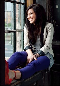 a woman sitting on top of a window sill