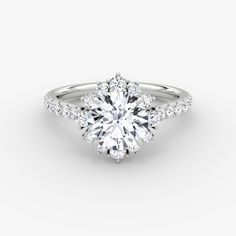 a white gold engagement ring with an oval cut diamond surrounded by pave set diamonds