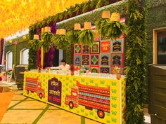 an outdoor food stand decorated with plants and decorations