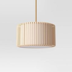 a white lamp hanging from a ceiling with a gold colored metal frame and pleated shade