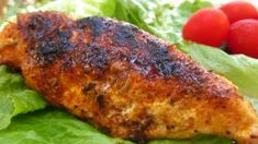 a close up of a plate of food with lettuce and tomatoes in the background