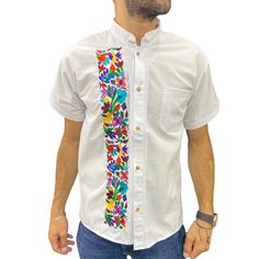 Typical Mexican Guayabera type shirt. Made by our Chiapanecan artisans by machine on a white or black blanket. Although they follow the same pattern, the colors of the embroidery may vary from piece to piece. It has a mandarin collar and has a pocket. Mexican Artisan Design. Material: blanket (cotton). Sizes: Ch, M, G and EG. Primary color: white or black. Machine made. Availability of colors and sizes is limited. The photos are just a sample of what is available. Please ask to be sent a photo of those we have in stock for your selection when making the purchase. White Traditional Fit Shirt For Spring, Traditional Fit White Shirt For Spring, White Regular Fit Shirt For Spring, Traditional Short Sleeve Shirt With Multicolor Embroidery, Multicolor Embroidered Short Sleeve Shirt, Traditional White Embroidered Shirt, White Cotton Tops With Traditional Patterns, White Cotton Top With Traditional Patterns, Traditional Fitted White Shirt