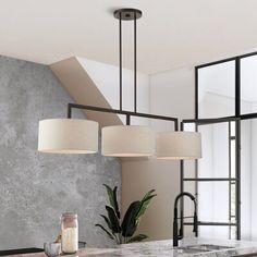 a kitchen with marble counter tops and pendant lights