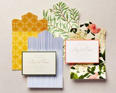 the wedding stationery is laid out on top of each other, with different colors and patterns