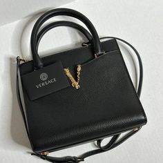 An Authentic Versace Grained Calfskin Virtus Top Handle Tote. The Bag Is Brand New, Original And Never Worn. It's Perfect And Comes With Versace Dust Bag And Authenticity Card. 100% Smooth Calfskin Leather Approximate Measurements: Height: 7.9" Width: 3.9" Length: 9" Strap Drop: 3.5" Shoulder Strap Drop: 23.5" Black With Gold Versace V Embellishment. Magnetic Closure Made In Italy Versace Bags, Knee High Leather Boots, Magnetic Closure, Top Handle, Leather Boots, Knee High, Calf Skin, Versace, Dust Bag