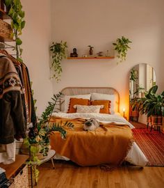 a bed sitting in a bedroom next to a mirror and potted plant on a shelf