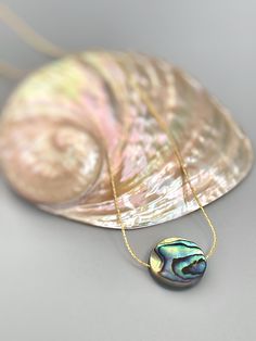 Handmade genuine Abalone necklace. A dainty solitaire necklace for women with an iridescent Abalone Shell on a delicate sterling silver or 14k gold filled  chain. Perfect summer or beach necklace. A simple, elegant  necklace perfect for everyday wear.  Gemstone size: 14mm tall x 14mm wide (approx 1/2") PLEASE note measurements and size reference pictures. Our jewelry and hair accessories are photographed close up to show detail and may appear larger than they are. We are happy to help with any q Gold Abalone Shell Pendant Jewelry, Adjustable Iridescent Round Necklaces, Elegant Adjustable Abalone Shell Necklace, Elegant Gold Jewelry With Abalone Shell, Elegant Gold Abalone Shell Jewelry, Elegant Adjustable Iridescent Necklaces, Elegant Iridescent Adjustable Necklaces, Adjustable Dainty Mother Of Pearl Jewelry, Elegant Iridescent Adjustable Necklace