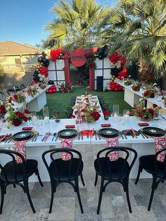 a table set up with red and black place settings