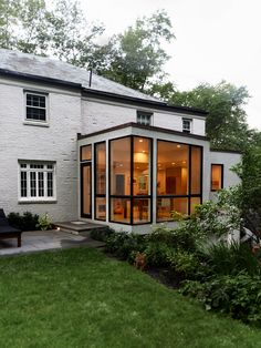 a white brick house with glass walls and windows