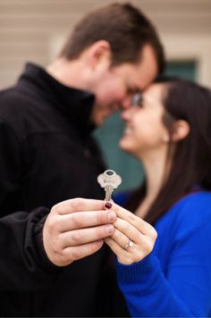 a man holding a key to a woman's face