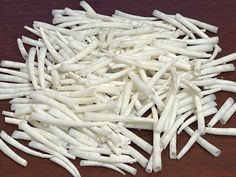 a pile of white toothpicks sitting on top of a wooden table