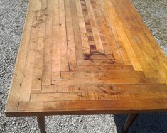 a wooden table sitting on top of gravel covered ground