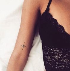 a woman's arm with a small star tattoo on the left side of her arm