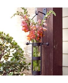 a vase filled with flowers sitting on top of a wooden door frame next to a planter