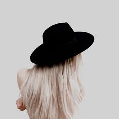 the back of a woman's head wearing a black hat with long blonde hair