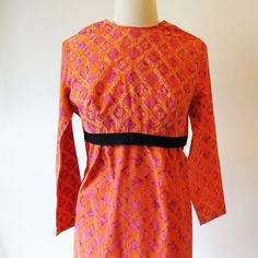 60s orange dress has long sleeves an empire waist and back metal zipper, Cute 1960 sheath style dress of orange and pink batik patterned cotton. Small vintage dress Measurements with room for comfort Bust- up to 34 inches Waist- up to 30 inches Hips- up to 35 inches Exact measurements taken flat to compare to a garment you own Length- 39 1/2 inches Sleeve length- 21 inches Bust- 17 1/2 inches Waist- 16 inches Hips- 18 inches Condition- Excellent Clean and ready to wear Brand / Designer- Home Mad Retro Long Sleeve Orange Dresses, Retro Orange Long Sleeve Dress, Fitted Orange Mod Dress, Orange Fitted Mod Dress, Orange Mod Fitted Dress, Plaid Dress Vintage, Empire Waist Gown, Long Sleeve Cotton Dress, Cotton Frocks