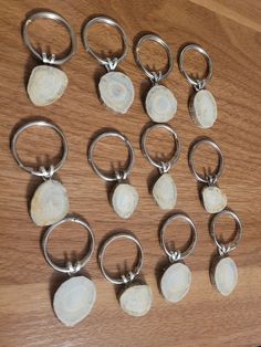 several different sized and shaped metal rings on a wooden table with rocks in the middle