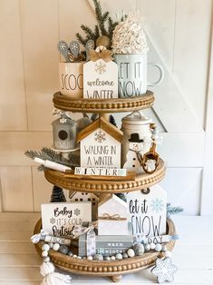 a three tiered christmas tree decorated with holiday cards and other decorations on top of it