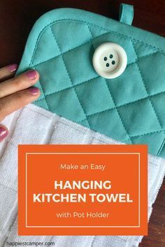 a woman's hand holding a teal kitchen towel with a button on it