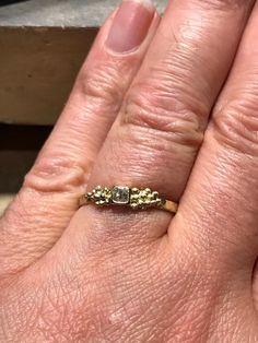 a woman's hand with a yellow gold ring on top of her left hand