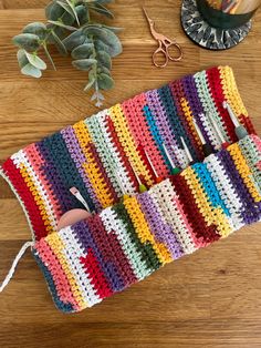 a crocheted pot holder with scissors and other crafting supplies on a wooden table