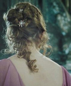 the back of a woman's head wearing a pink dress