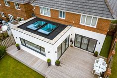 an aerial view of a house with a pool in the backyard and decking area