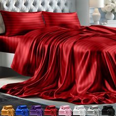 a bed covered in red sheets and pillows