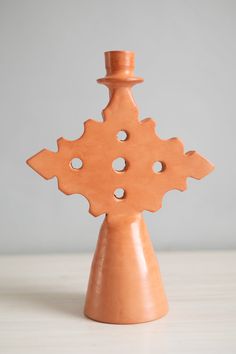 an orange vase sitting on top of a table