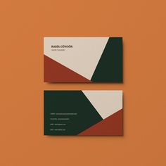 two business cards sitting on top of an orange surface, one with green and red accents