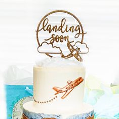 there is a cake with a plane on it and the words landing soon above it