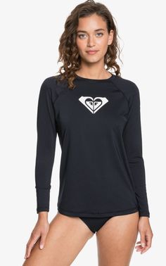 a woman wearing a black and white long sleeved top with a heart on the chest