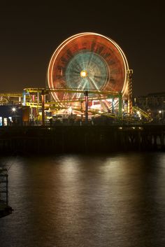 the ferris wheel is lit up at night