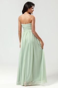 a woman in a strapless dress is looking back at the camera and she has her hand on her hip