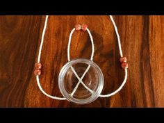 a glass jar with two strings attached to it on top of a wooden table next to a string