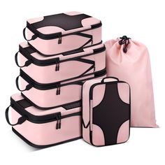 five pieces of pink luggage sitting next to each other in front of a drawsack bag