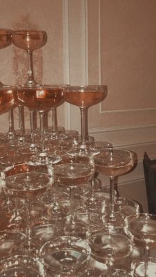 a table topped with lots of glasses filled with liquid and wine goblets sitting on top of each other