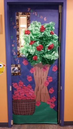 a door decorated with paper flowers and leaves for the classroom's school year celebration