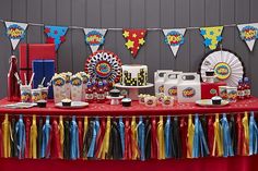 a red table topped with cake and cupcakes next to a carnival theme banner