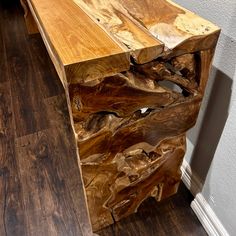 a wooden table that has been made out of some kind of tree trunk and is sitting on the floor