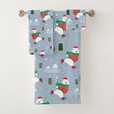 two towels hanging on a towel rack with snowmen and christmas trees in the background