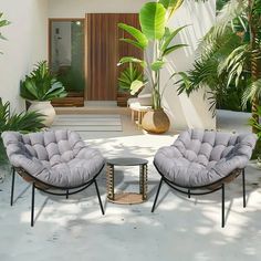 two chairs sitting on top of a white floor next to plants