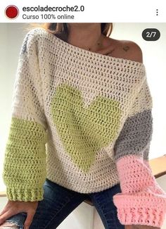 a woman is wearing a sweater with hearts on it